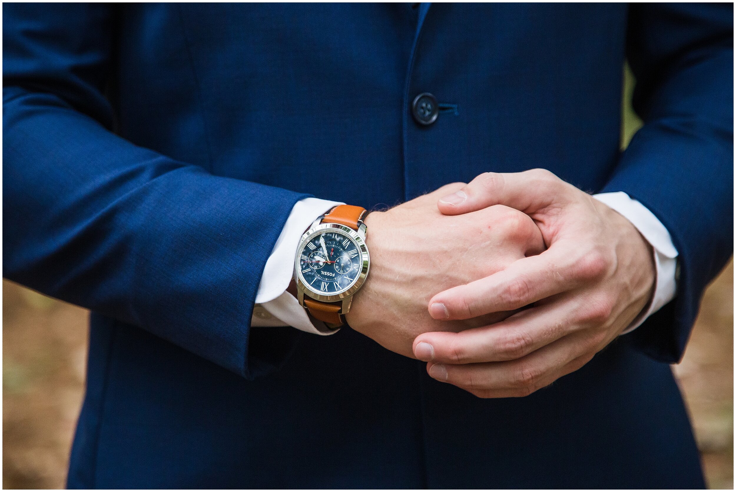 closeup photo of groom with watch and suit