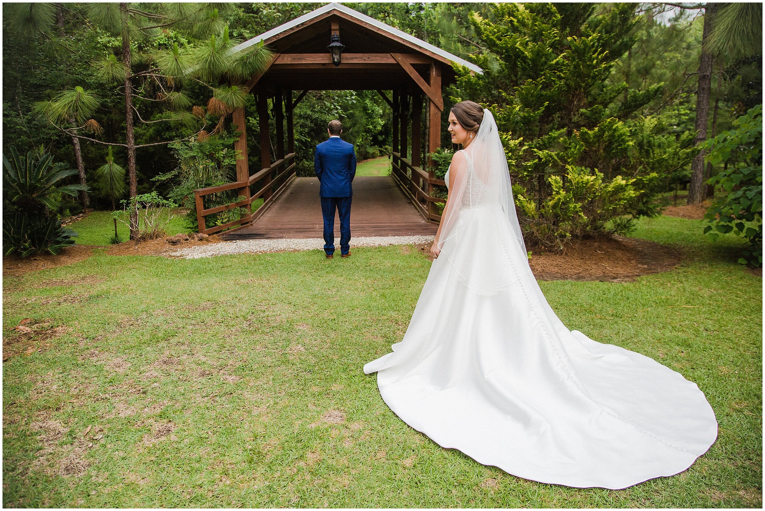 groom standing with back to bride before first look at the covered bridge at bella sera gardens