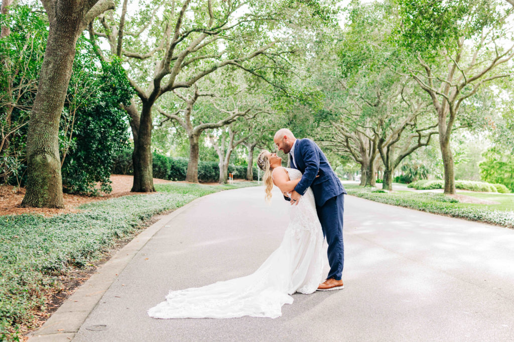 Groom dips bride under oak trees at Sandestin Resort in Destin Florida