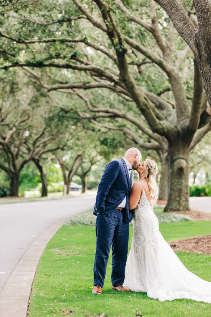 Bride and groom kiss under oak trees at Sandestin Resort in Miramar Beach Florida