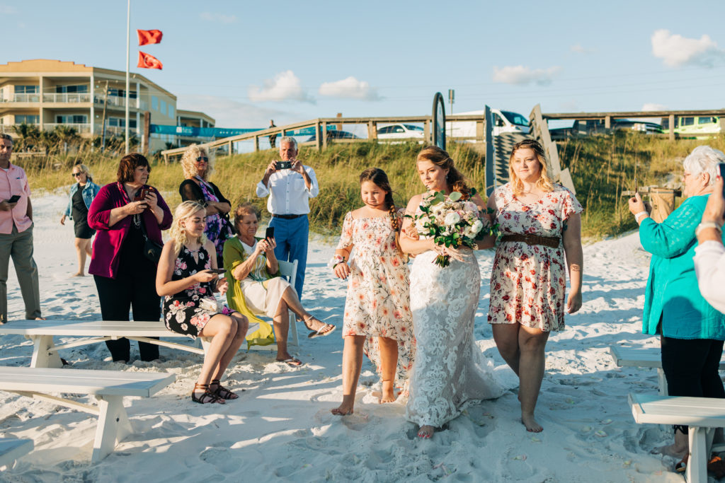 bride walks down her wedding aisle in Miramar Beach Florida escorted by her two nieces