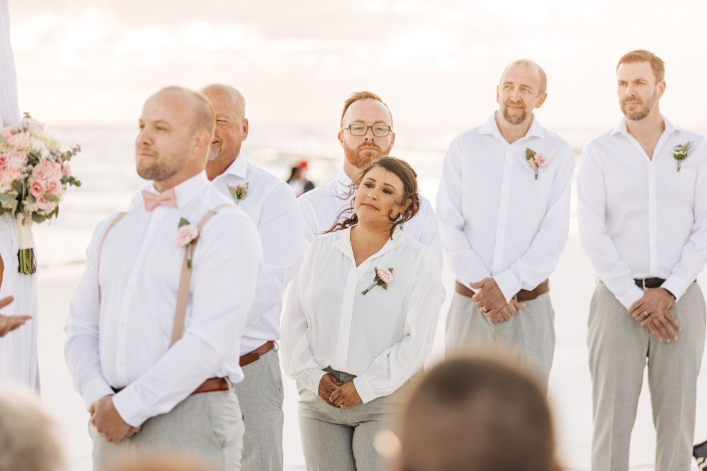 groomsmen and groomswoman stand for wedding ceremony on Miramar Beach