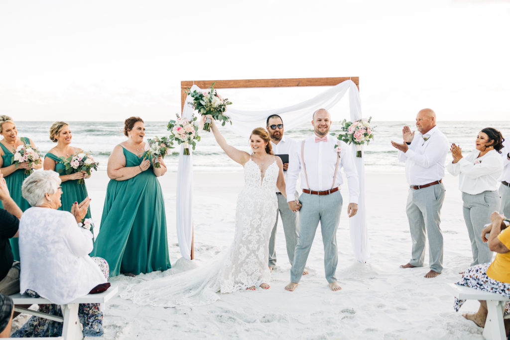bride and groom celebrate being pronounced husband and wife on Miramar Beach Florida