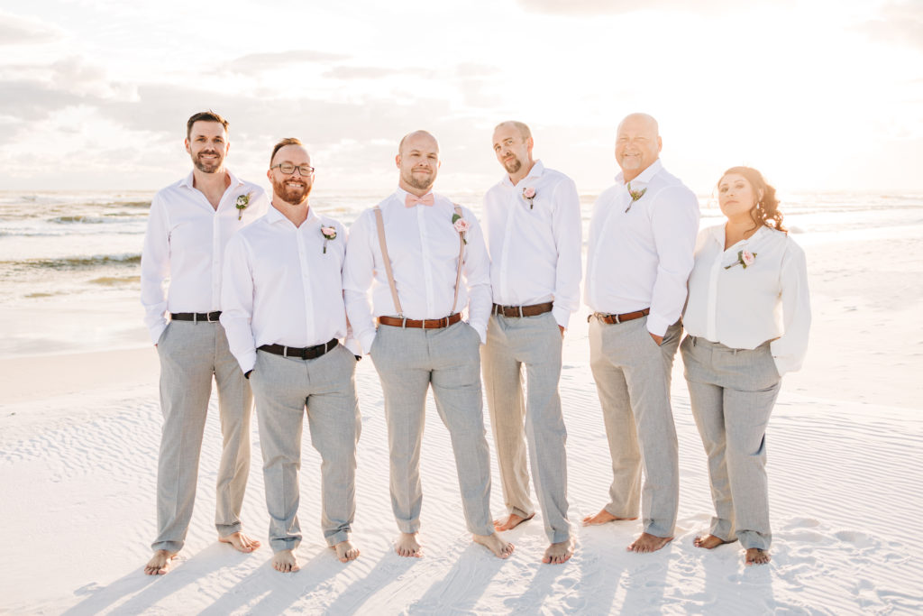 groomsmen and groom laugh on the beach after ceremony in Destin Florida
