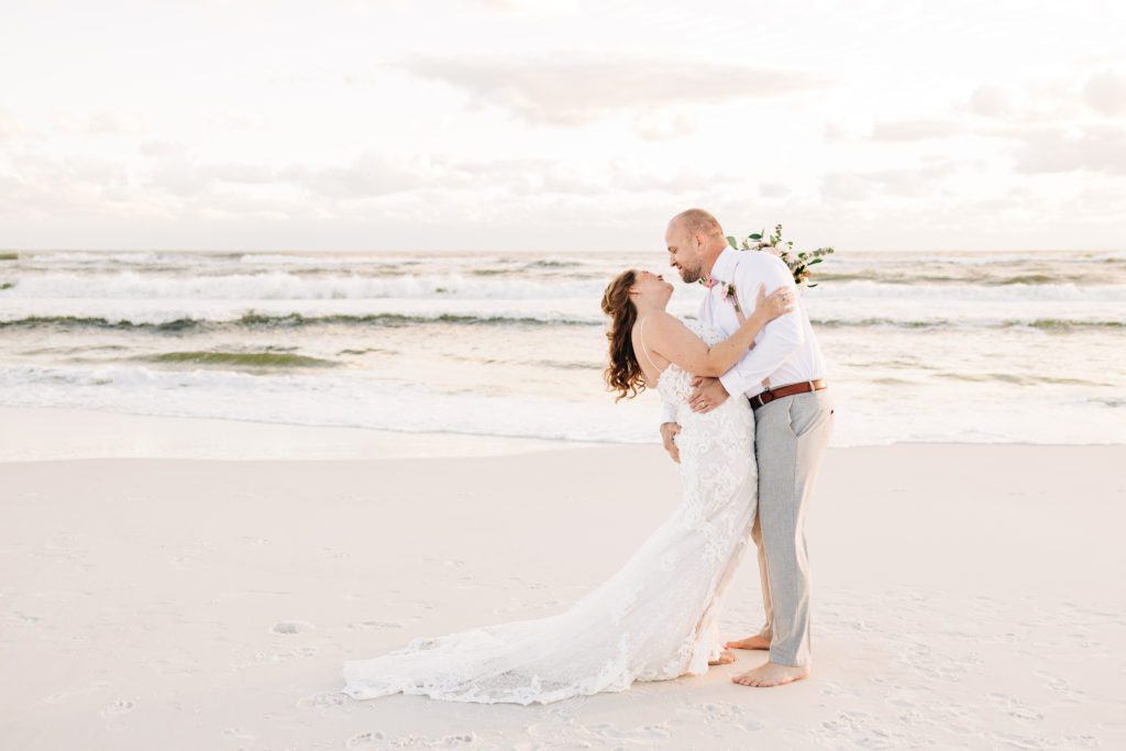 Groom dips bride by the gulf on Miramar Beach Florida