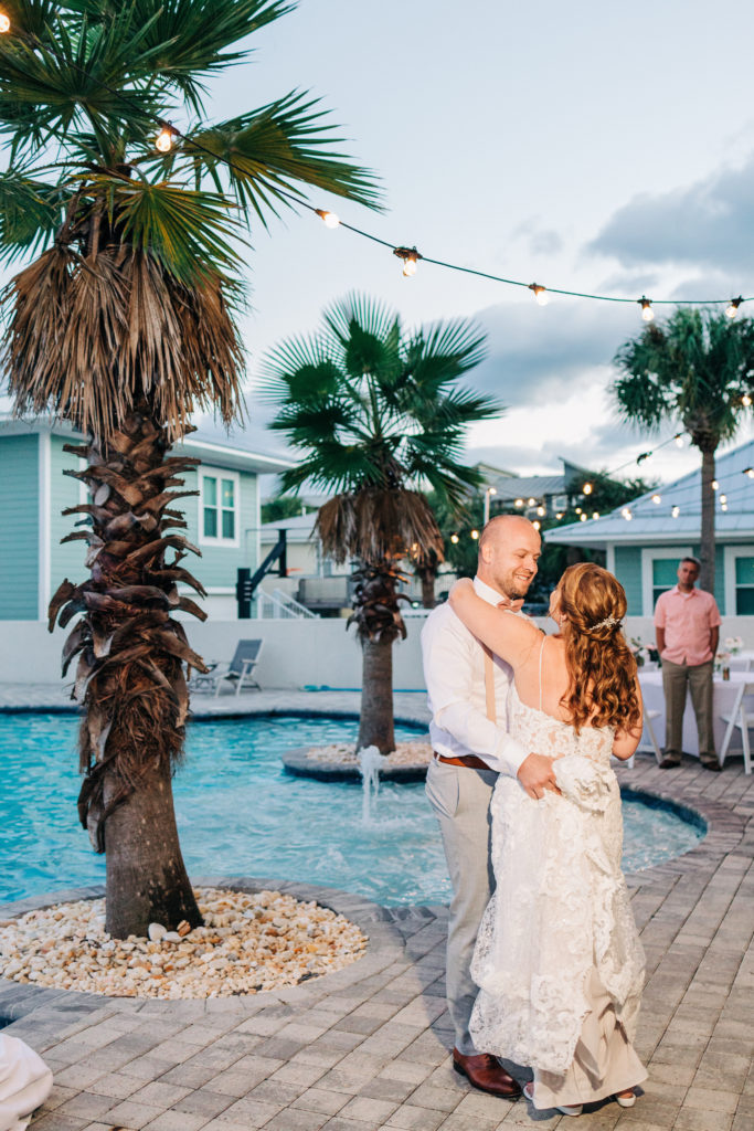 bride and groom dance poolside at their wedding reception in miramar beach florida